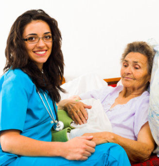 Smiling nurse caring for kind elder patient in nursing home