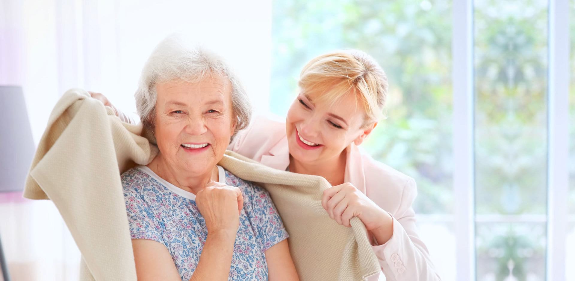 beautiful caregiver and senior woman smiling