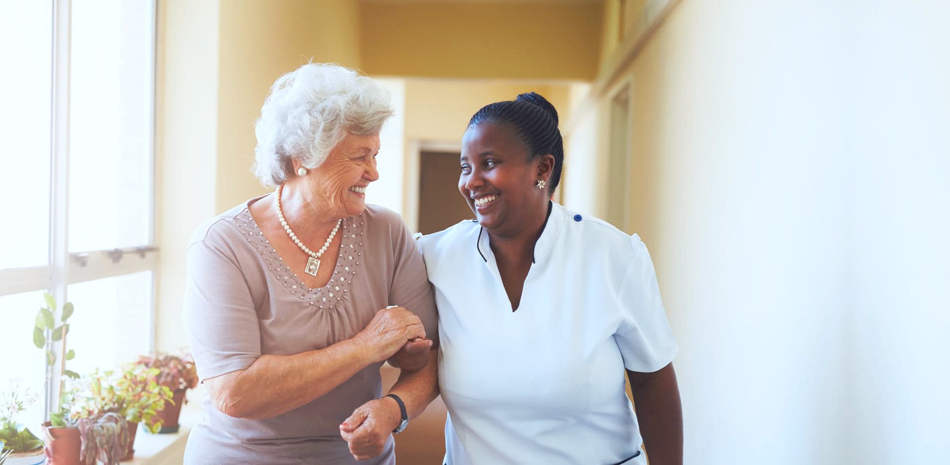 caregiver and senior woman walking together