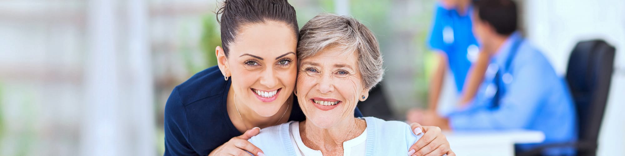 sitting senior and beautiful caregiver smiling