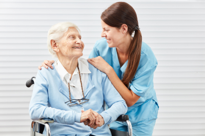 female caregiver with an old woman in wheelchair